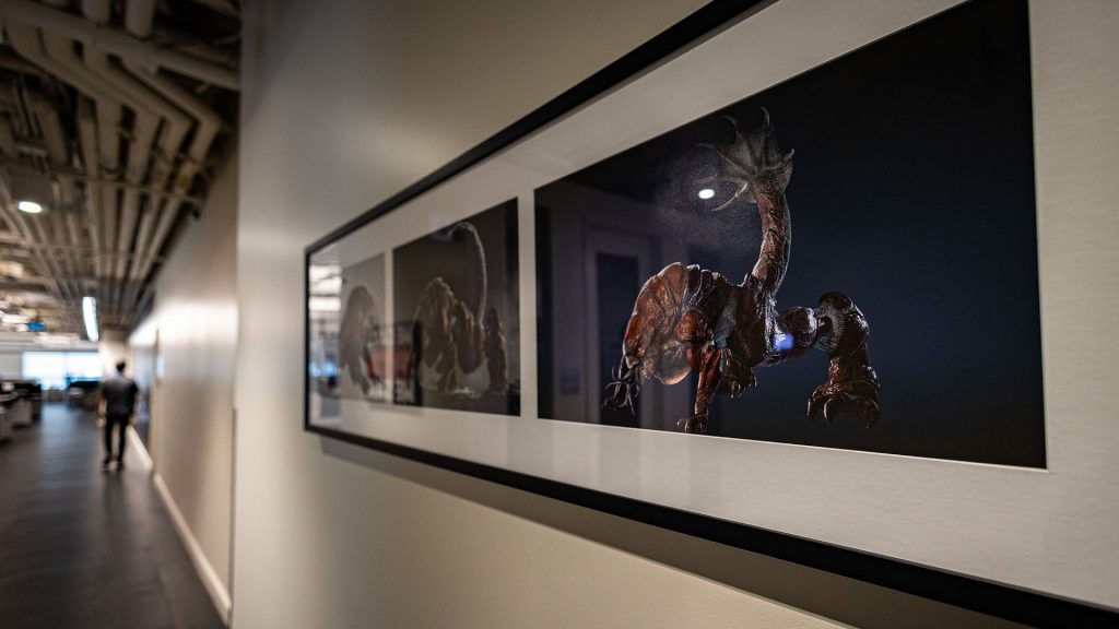 A frame showing a concept art of a swarm monster hanged on the wall of the studio.